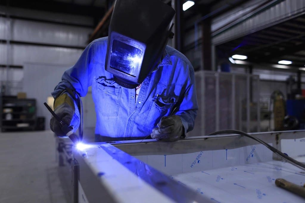 A welder at work in a manufacturing facility.